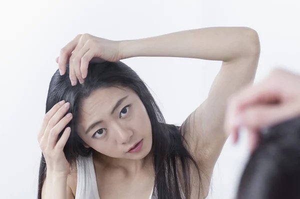 Νεαρά Ασιατικές Γυναίκα Αγγίζει Μαλλιά Της Και Κοιτάζοντας Στον Καθρέφτη — Φωτογραφία Αρχείου