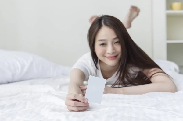 Genç Asyalı Kadın Yatakta Yatıyordu Kredi Kameraya Gösteren Gülümseyen Bir — Stok fotoğraf
