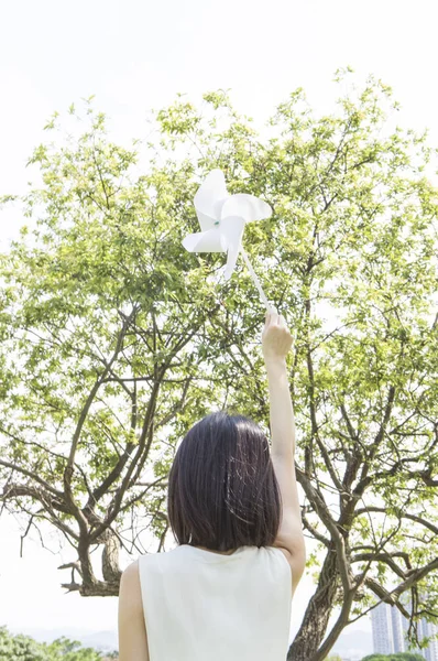 年轻的亚洲女子举起风车 向镜头展示自己的背影 — 图库照片