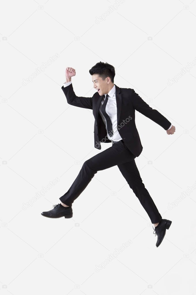 Young Asian man wearing a suit jump up high and smiling,