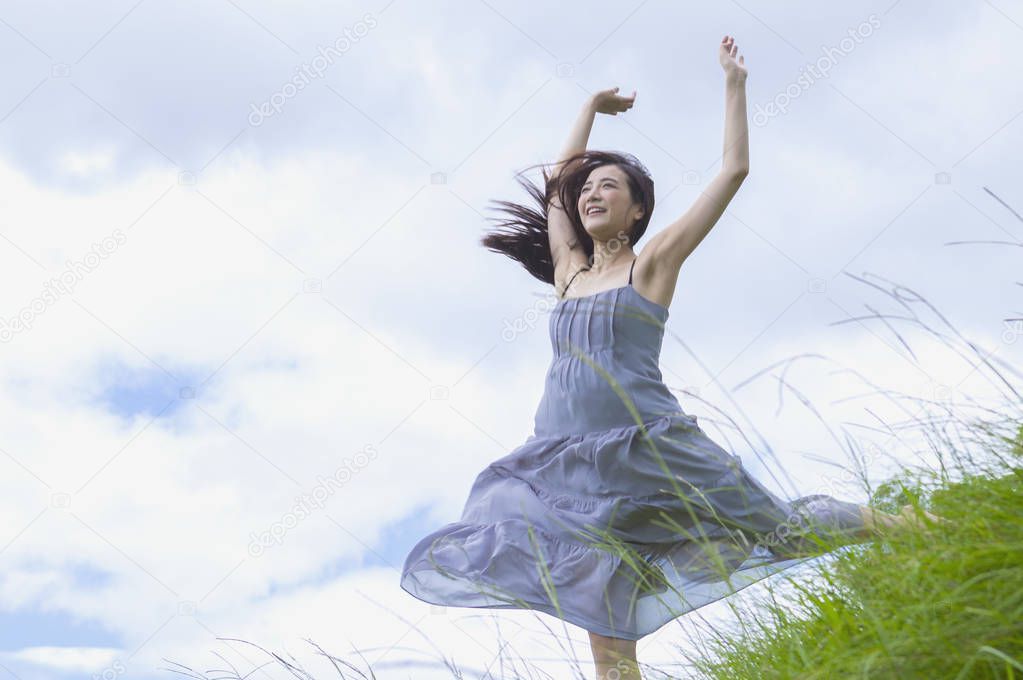 Young Asian woman jump up high and smiling looking away