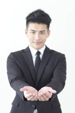 Dayanabiliyor ve kameraya bakarak Genç Asyalı adam bir takım elbise eller