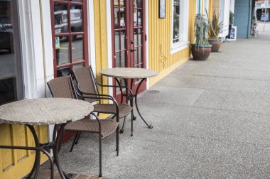 Sandalyeleri ve masaları olan sokak kafesi.  