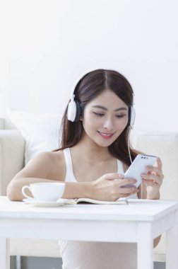 Müzik gülümseyen Genç Asyalı kadın