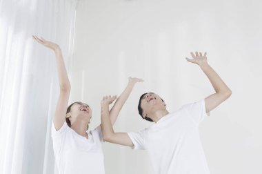 Genç çift eller yukarı ve gülümseyen uzağa arıyorsunuz