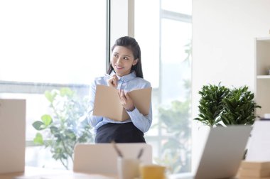 Takım elbiseli bir not alma ve uzağa arıyorsunuz gülümseyen genç kadın