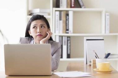 Çenesinin altına uzağa bakarak bir takım elbise eller genç kadın