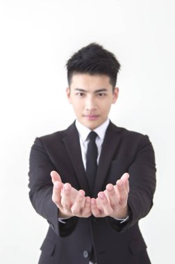 Dayanabiliyor ve kameraya bakarak Genç Asyalı adam bir takım elbise eller