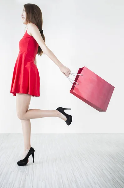 Mujer Joven Con Vestido Rojo Sosteniendo Una Bolsa Corriendo —  Fotos de Stock