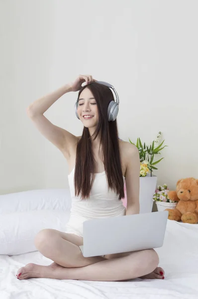 Jovem Mulher Asiática Sentada Cama Usando Fone Ouvido Sorrindo Usando — Fotografia de Stock