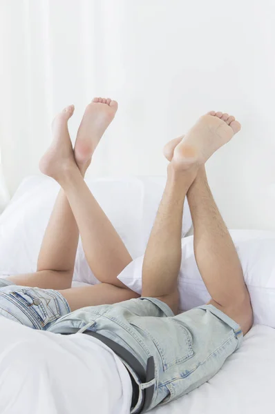 Junges Paar Liegt Auf Dem Bett Und Kreuzt Die Beine — Stockfoto