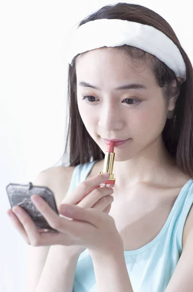 彼女の顔に化粧を置く若いアジア女性 — ストック写真