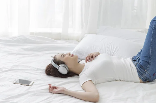 Jovem Mulher Asiática Deitada Cama Sorrindo Ouvindo Música — Fotografia de Stock