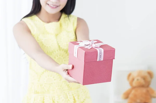 年轻女孩微笑着向镜头展示礼物 — 图库照片