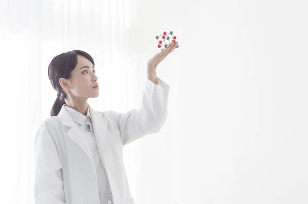 Young Female Doctor Holding Gene Model Looking — Stockfoto