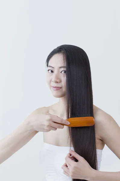 Young Asian Woman Brushing Her Hair Smiling Camera — Stock Photo, Image