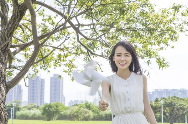 Mladá Asijská Žena Držící Větrný Mlýn Usmívá Zobrazeno Fotoaparátu — Stock fotografie