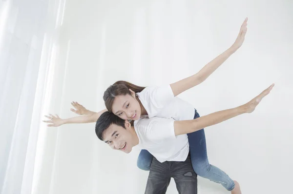 Young couple arms open and smiling at the camera