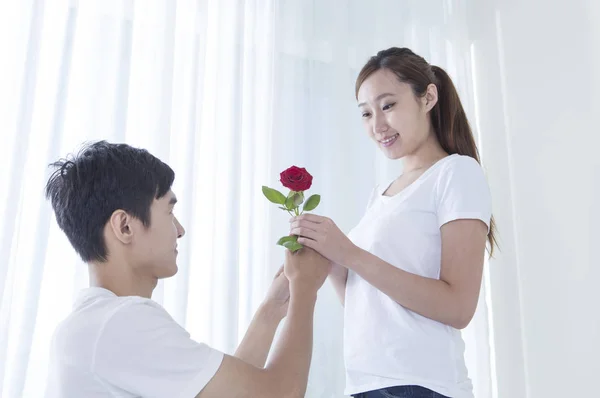 Joven Sosteniendo Rosa Roja Dándosela Una Joven — Foto de Stock