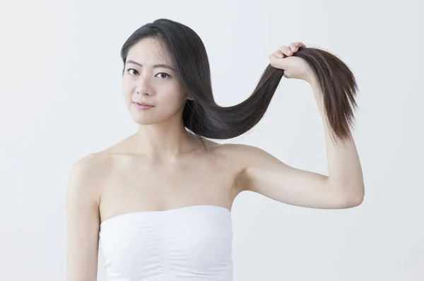 Молоді Азіатські Жінки Тримаючи Волосся Посміхається Камеру — стокове фото