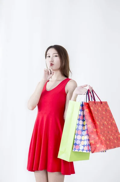 Mujer Joven Con Vestido Rojo Sosteniendo Algunas Bolsas Sonriendo Cámara — Foto de Stock