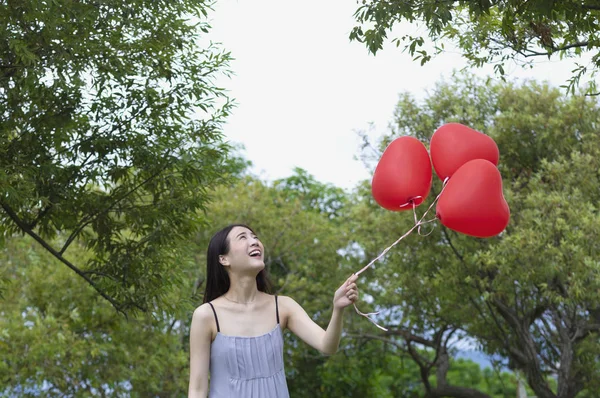 Mladá Asijská Žena Drží Balónky Usmívá Koukal — Stock fotografie