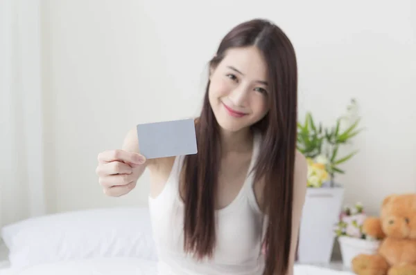クレジット カードを持っているとカメラにそれを示す笑顔の若いアジア女性 — ストック写真