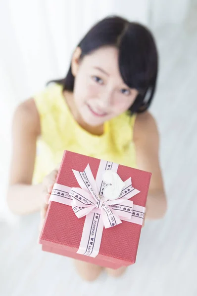 Junges Mädchen Lächelt Und Zeigt Der Kamera Ein Geschenk — Stockfoto