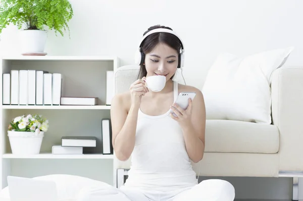 楽しく音楽を聴くと コーヒーを飲む若いアジアの女性 — ストック写真
