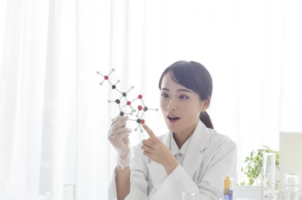 Young Female Doctor Holding Gene Model Looking — Stock fotografie