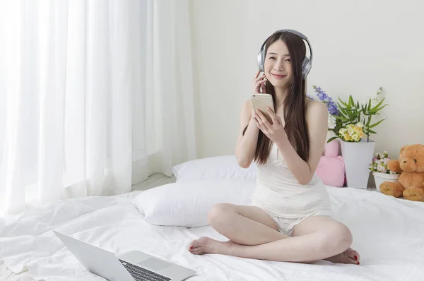 Jovem Mulher Asiática Segurando Seu Telefone Celular Usando Fone Ouvido — Fotografia de Stock