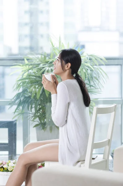 Mujer Joven Sentada Sofá Sonriendo Mirando Hacia Otro Lado — Foto de Stock