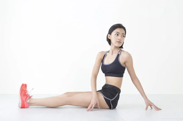 Ung Asiatisk Kvinna Sitter Golvet Stretching Själv Och Tittar Bort — Stockfoto