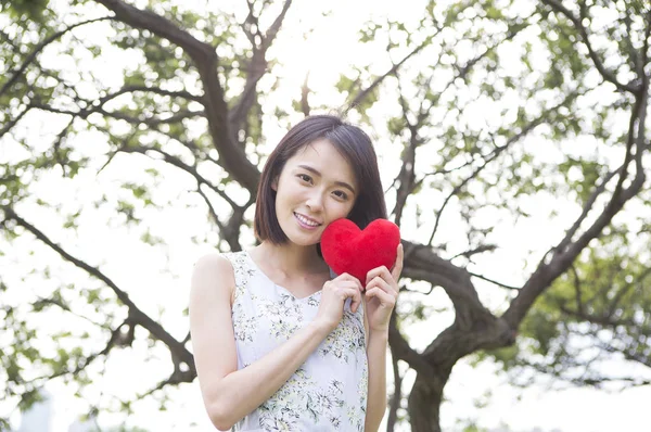 Bir Kalp Tutan Kameraya Gülümseyen Genç Asyalı Kadın — Stok fotoğraf