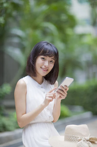 Jovem Mulher Vestido Branco Sorrindo Usando Telefone Celular Floresta — Fotografia de Stock