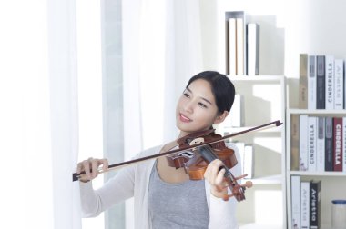 Bir Keman çalmaya ve uzağa arıyorsunuz gülümseyen genç kadın