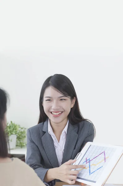 Jovem Mulher Asiática Terno Sorrindo Mostrando Gráfico Para Uma Mulher — Fotografia de Stock