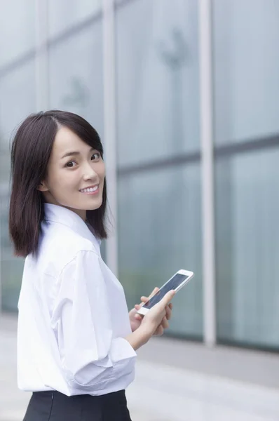 Mulher Asiática Jovem Terno Segurando Telefone Celular Sorrindo Para Câmera — Fotografia de Stock