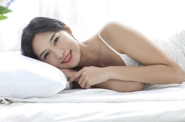 ベッドに横たわって カメラで笑顔若いきれいな女性 — ストック写真