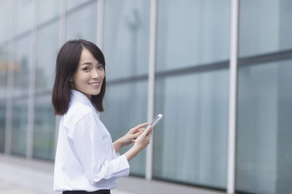 携帯電話をかざして カメラで笑顔のスーツを着ている若いアジア女性 — ストック写真