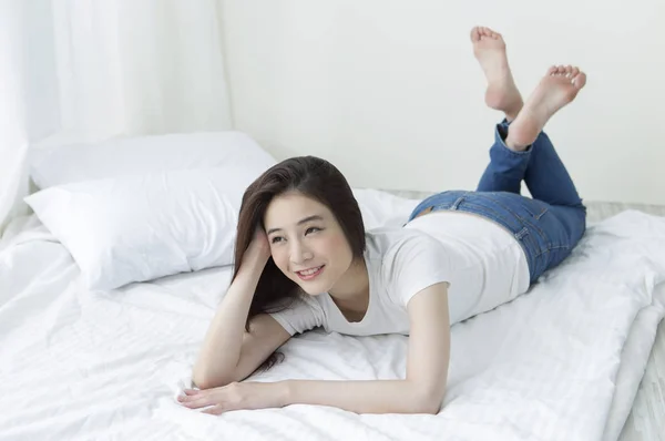 Joven Asiática Mujer Jeans Acostada Cama Sonriendo Mirando Hacia Otro — Foto de Stock