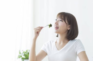 Yemek suşi gülümseyen Genç Asyalı kadın