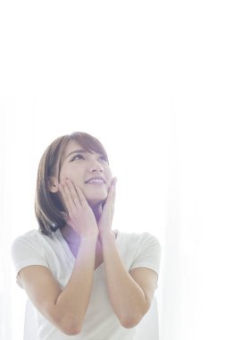 Genç Asyalı kadın çenesinin ve rüya bir gün gülümseyerek altında eller