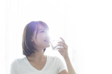 Bir bardak su içme gülümseyen Genç Asyalı kadın