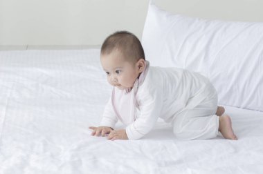 Yatağa tırmanma genç Asya bebek