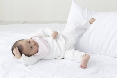 Genç Asyalı bebek yatakta yatıyordu