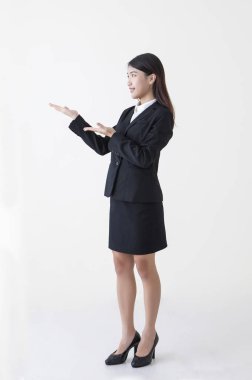 Yukarı ve gülümseyen uzağa bakarak bir takım elbise giymiş genç Asyalı kadın eller,