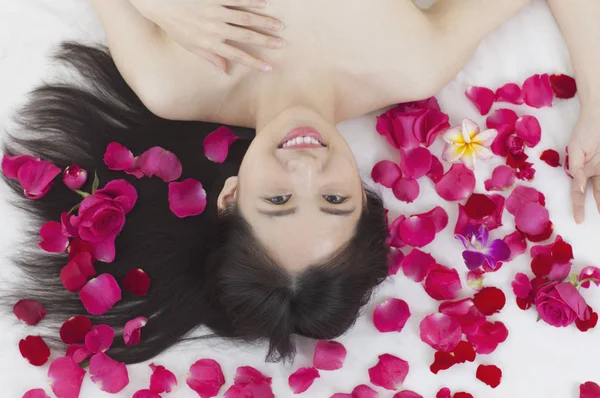 Jovem Mulher Asiática Deitada Sobre Algumas Rosas Sorrindo Para Câmera — Fotografia de Stock