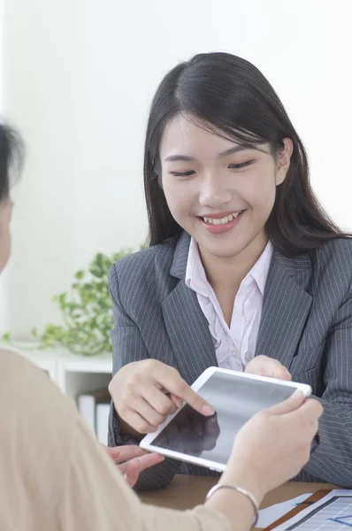 Jovem Ásia Mulher Vestindo Terno Sorrindo Mostrando Tablet Para Outros — Fotografia de Stock