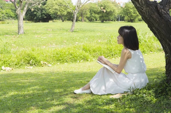 Jovem Mulher Asiática Vestindo Vestido Branco Lendo Livro Sob Árvore — Fotografia de Stock